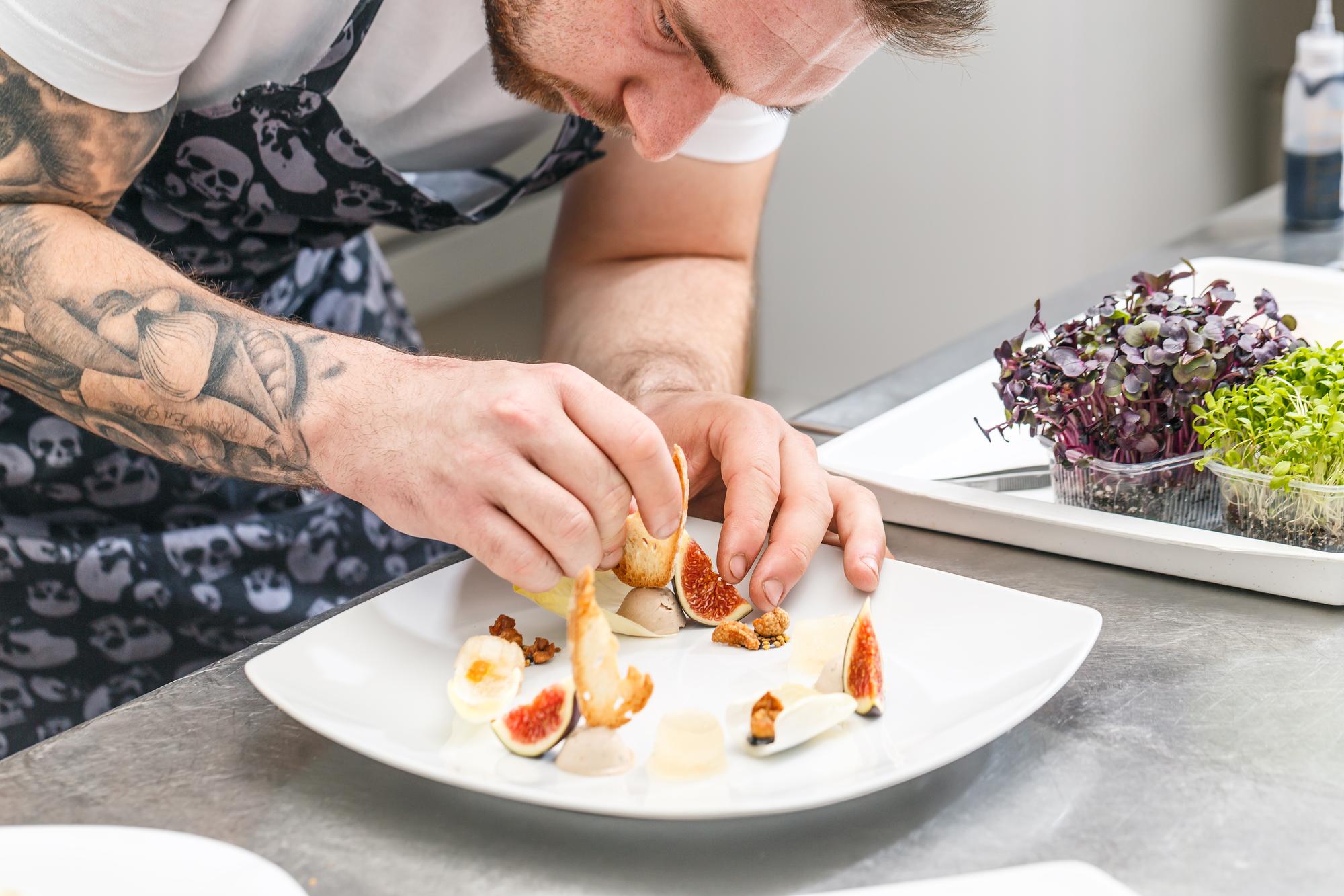Chef teaching plating techniques in a calm kitchen